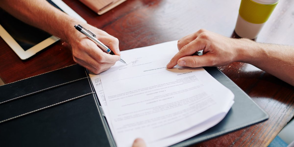 Close-up business people signing agreement after successful meeting